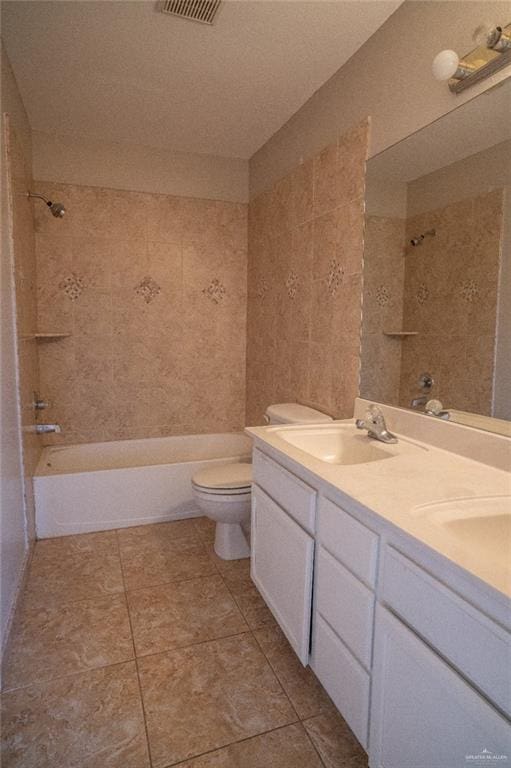 full bathroom with toilet, tiled shower / bath, and vanity