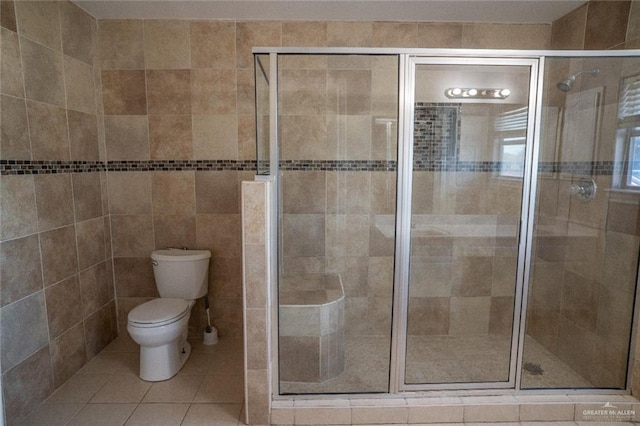 bathroom with a shower with shower door, tile patterned floors, and toilet