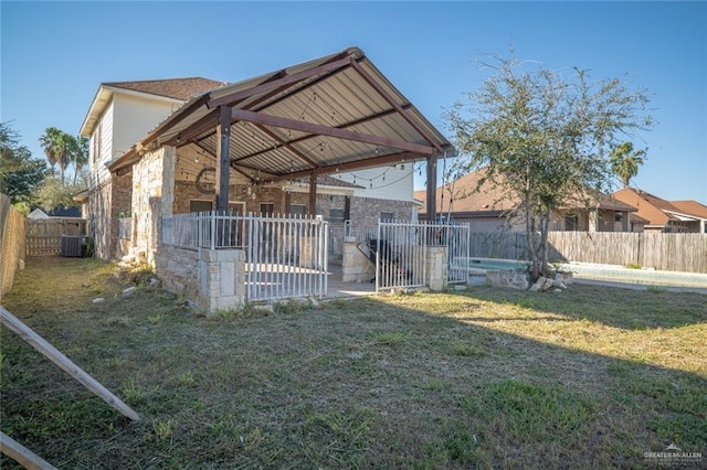 back of house featuring central AC unit and a yard