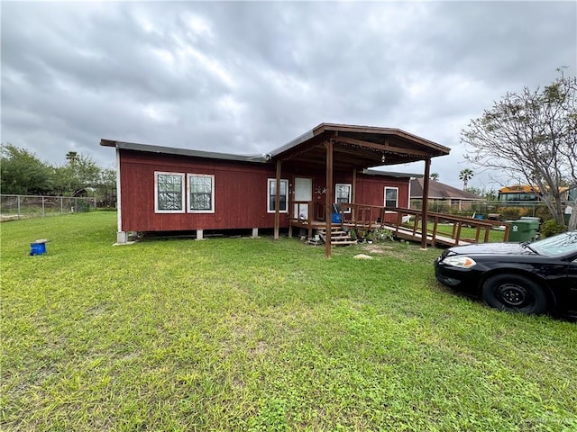 back of house featuring a lawn and a deck