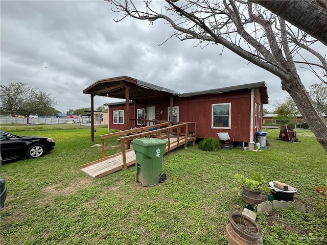 rear view of property featuring a yard and a wooden deck