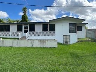 rear view of house featuring a lawn