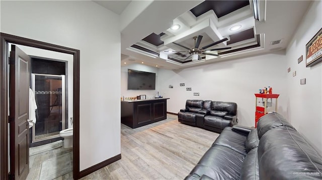 living room with ceiling fan, coffered ceiling, and light wood-type flooring