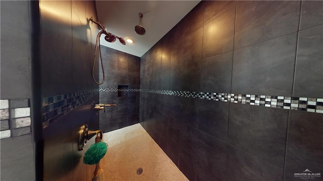 bathroom with lofted ceiling, tiled shower, and tile walls