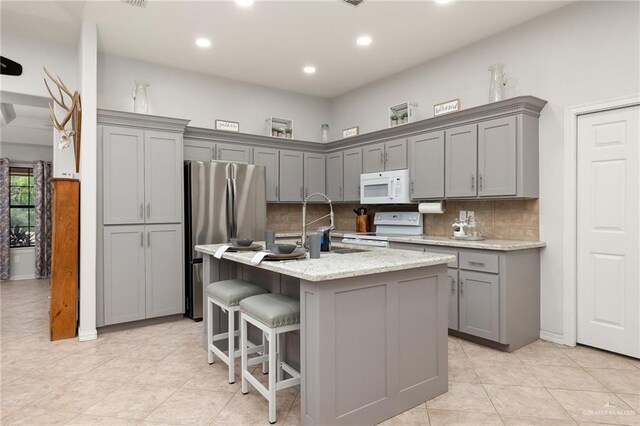 1612 W Military Hwy, Mission, TX 78572 - kitchen with gray cabinets, tasteful backsplash, light tile patterned floors, and white appliances