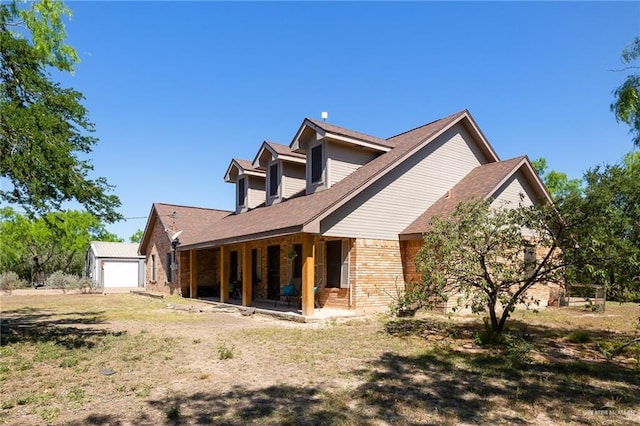 1612 W Military Hwy, Mission, TX 78572 - rear view of property featuring a shingled roof, brick siding, an outbuilding, and covered porch