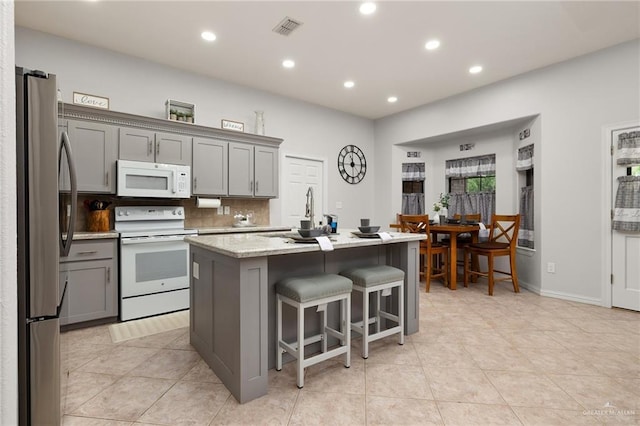 1612 W Military Hwy, Mission, TX 78572 - kitchen featuring recessed lighting, white appliances, gray cabinetry, and light tile patterned flooring