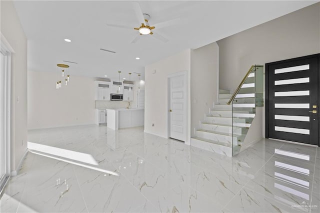 unfurnished living room featuring baseboards, stairs, recessed lighting, marble finish floor, and a ceiling fan