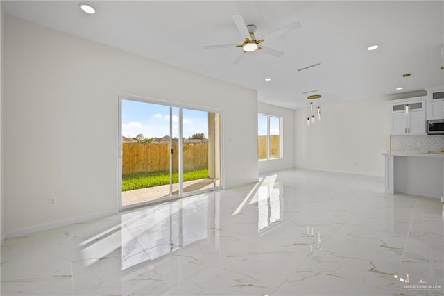 unfurnished living room with recessed lighting, baseboards, and marble finish floor