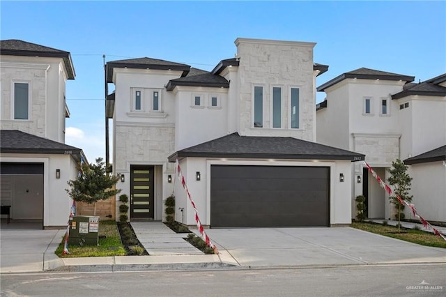 contemporary house with stone siding, stucco siding, driveway, and a garage