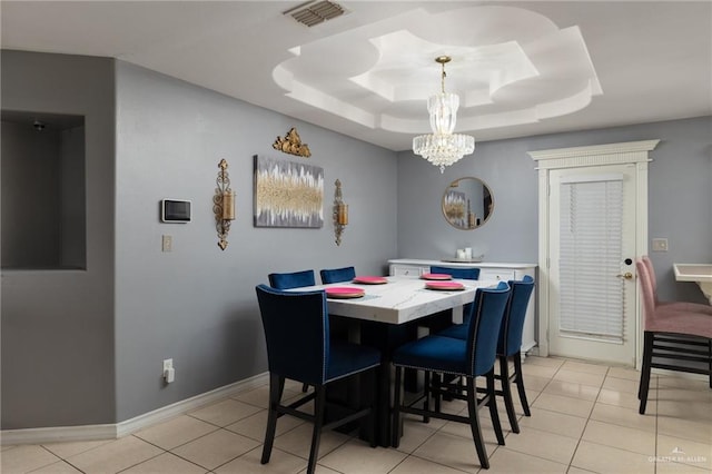 dining room with light tile patterned floors, baseboards, visible vents, and a raised ceiling