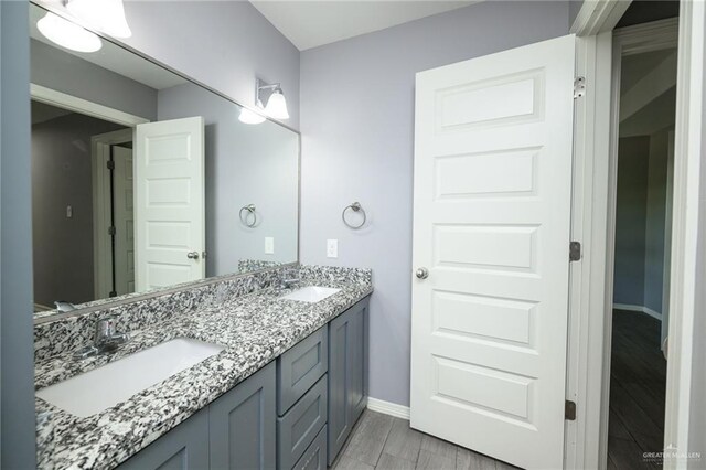 17236 Mandarin Ave, Harlingen, TX 78552 - full bathroom with double vanity, baseboards, and wood finished floors