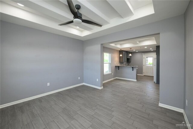 17236 Mandarin Ave, Harlingen, TX 78552 - unfurnished living room with ceiling fan, dark wood-style floors, a tray ceiling, and baseboards