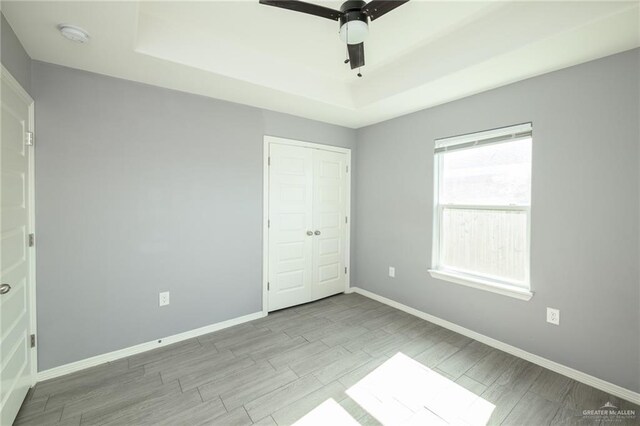 17236 Mandarin Ave, Harlingen, TX 78552 - unfurnished bedroom with a raised ceiling, wood finished floors, baseboards, and a closet