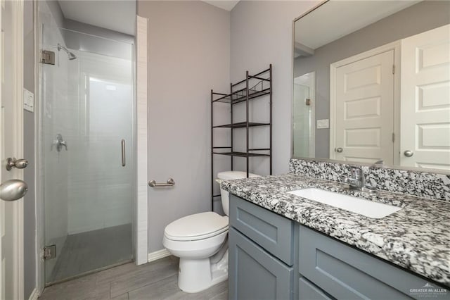17236 Mandarin Ave, Harlingen, TX 78552 - full bathroom with wood finished floors, a shower stall, vanity, toilet, and baseboards