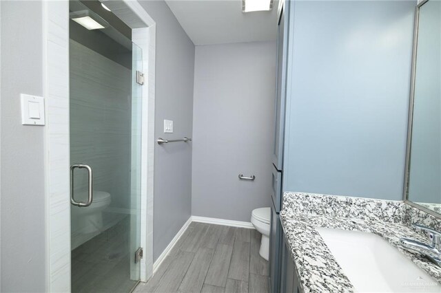 17236 Mandarin Ave, Harlingen, TX 78552 - full bathroom with toilet, vanity, wood finished floors, baseboards, and a shower stall