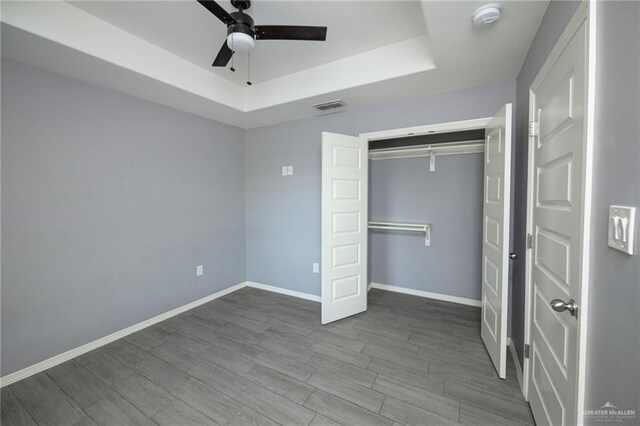 17236 Mandarin Ave, Harlingen, TX 78552 - unfurnished bedroom with a raised ceiling, baseboards, wood finished floors, a closet, and ceiling fan