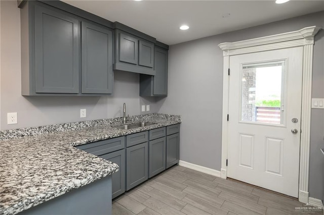 17236 Mandarin Ave, Harlingen, TX 78552 - kitchen featuring a sink, gray cabinetry, light wood-type flooring, recessed lighting, and light stone countertops