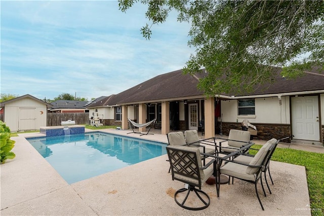 view of swimming pool featuring a patio area and a storage shed