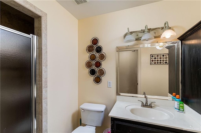 bathroom featuring walk in shower, vanity, and toilet