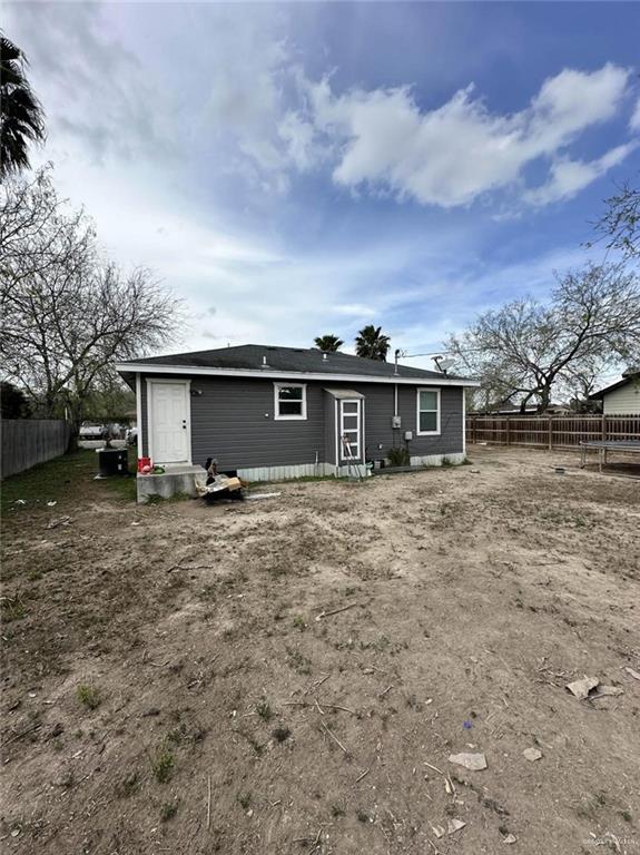 rear view of house featuring fence