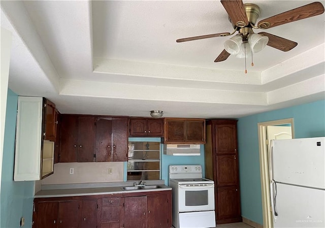 kitchen featuring a tray ceiling, sink, white appliances, and ceiling fan