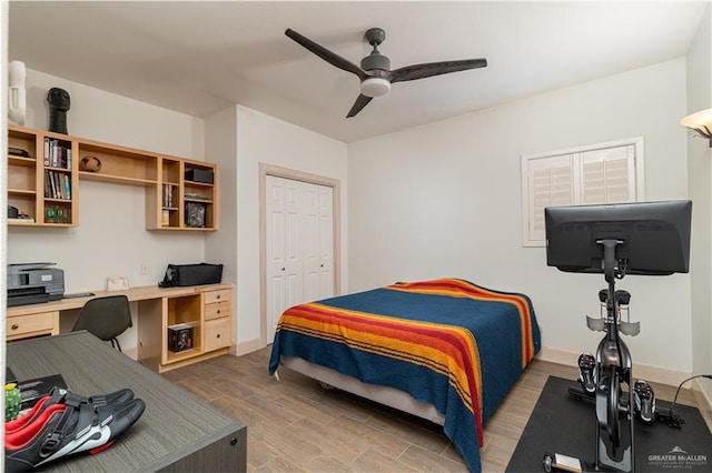 bedroom featuring a closet, ceiling fan, and built in desk