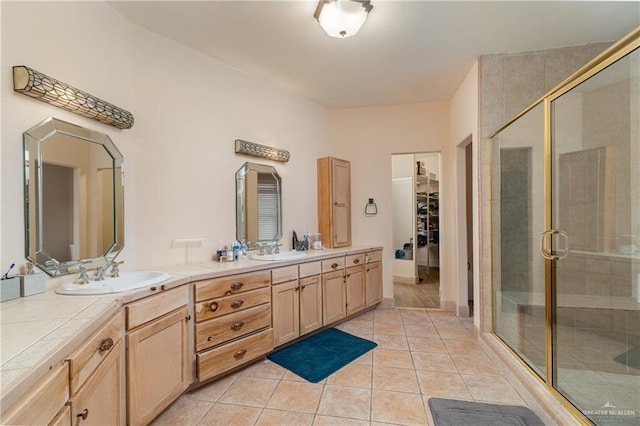 bathroom with a shower with door, tile patterned floors, and vanity