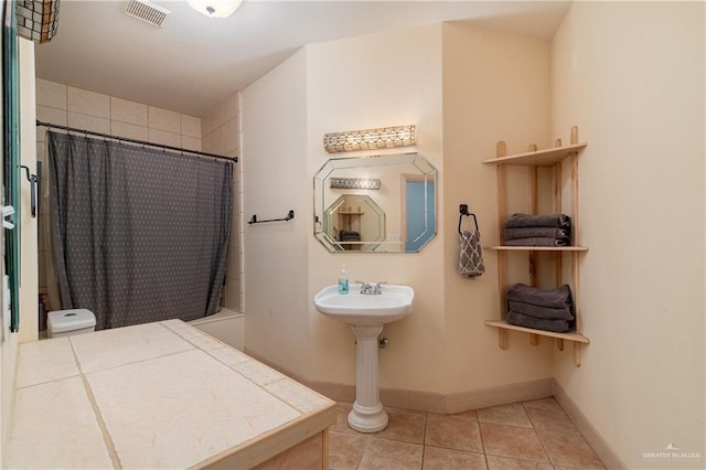 bathroom with curtained shower and tile patterned flooring