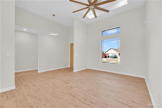 323 Santa Isabel, Rio Grande City, TX 78582 - empty room featuring a ceiling fan, light wood-style flooring, baseboards, and a high ceiling