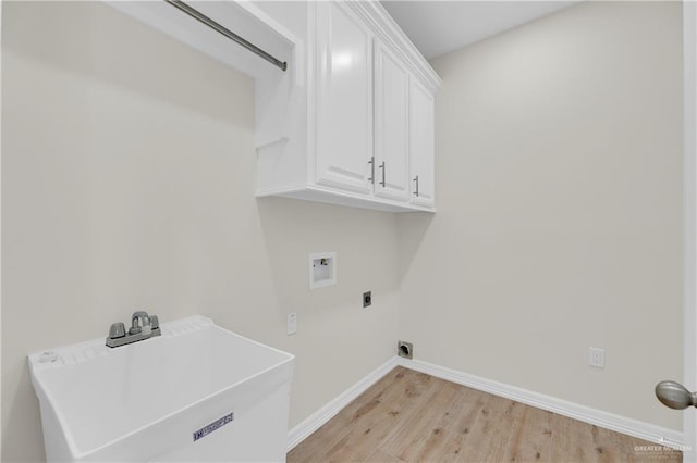 323 Santa Isabel, Rio Grande City, TX 78582 - clothes washing area with hookup for a washing machine, light wood-style flooring, cabinet space, electric dryer hookup, and baseboards