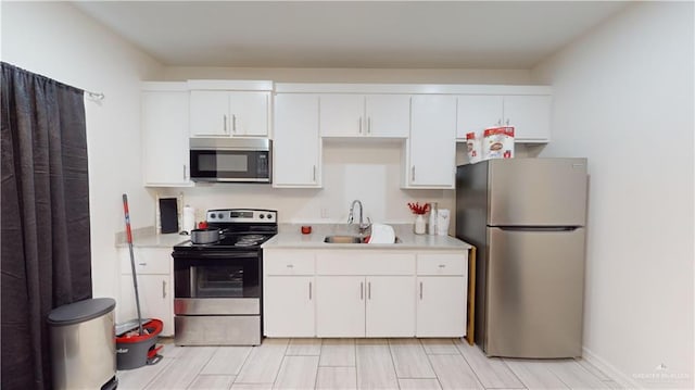 kitchen featuring white cabinets, appliances with stainless steel finishes, and sink