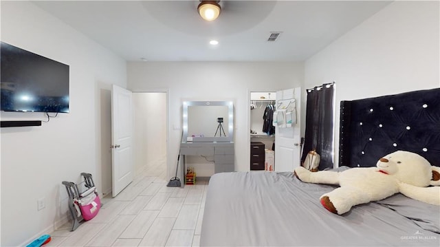 bedroom with ceiling fan, a spacious closet, and a closet