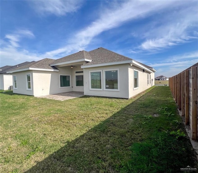 rear view of house with a lawn and a patio area