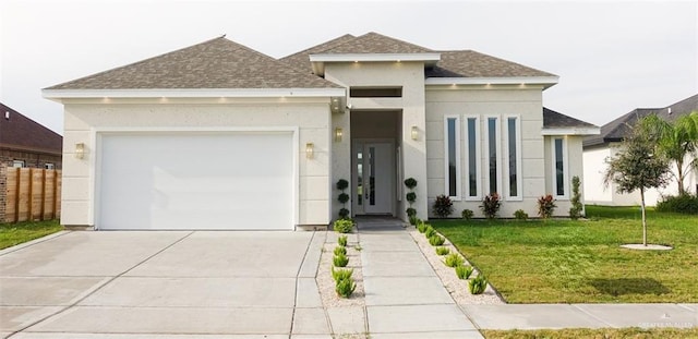 prairie-style home featuring a front yard and a garage