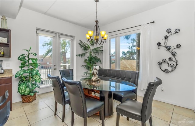 dining room with light tile patterned floors, a healthy amount of sunlight, and a notable chandelier