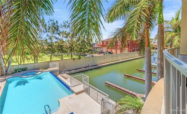 view of swimming pool featuring an in ground hot tub and a water view