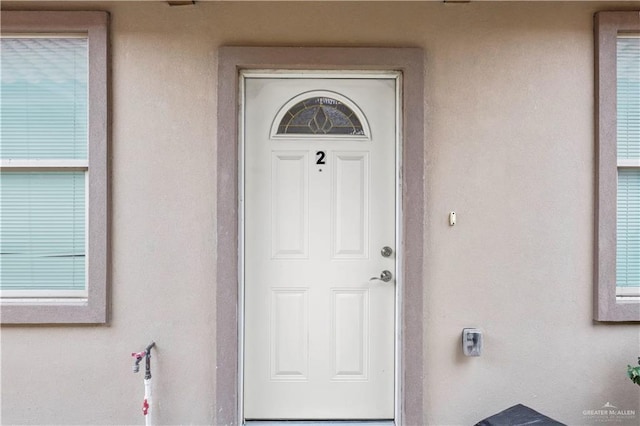 view of exterior entry featuring stucco siding