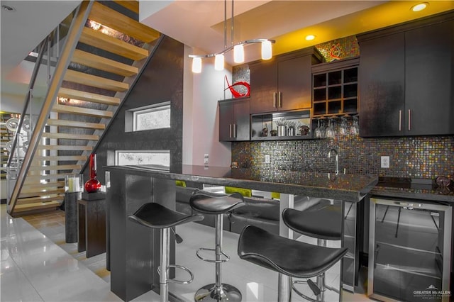 309 N Mockingbird Ave, Mission, TX 78572 - indoor wet bar featuring beverage cooler, stairway, tasteful backsplash, hanging light fixtures, and recessed lighting