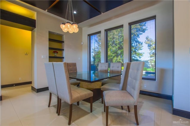 309 N Mockingbird Ave, Mission, TX 78572 - dining room featuring a chandelier, baseboards, healthy amount of natural light, a high ceiling, and built in shelves