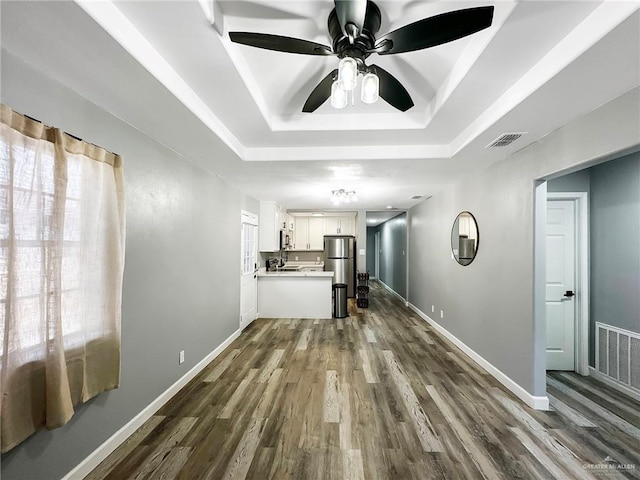 511 W Samano St, Edinburg, TX 78539 - unfurnished living room with dark wood finished floors, a tray ceiling, and a ceiling fan