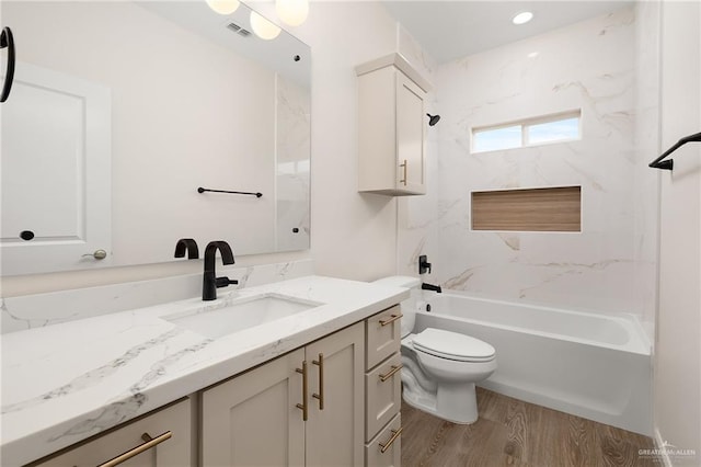 full bathroom featuring toilet, vanity, tiled shower / bath combo, and hardwood / wood-style flooring