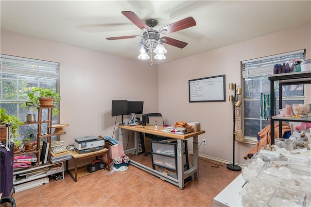 office space with light tile patterned flooring, a ceiling fan, and baseboards