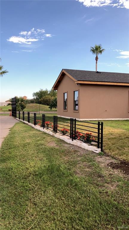 view of side of property featuring a yard and a rural view