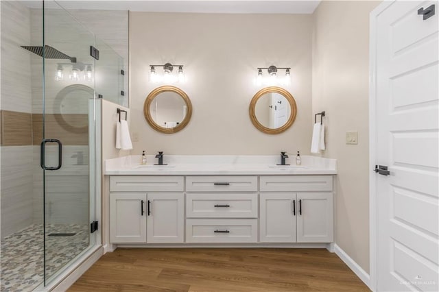 bathroom featuring vanity, an enclosed shower, and wood-type flooring