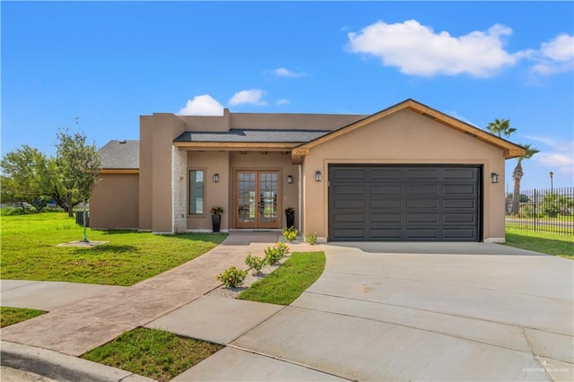 view of front of home with a front lawn, a garage, and french doors