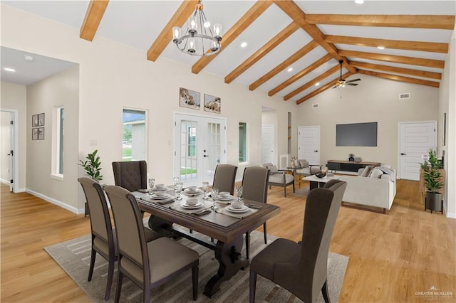 dining area with ceiling fan with notable chandelier, beam ceiling, light wood-type flooring, and high vaulted ceiling