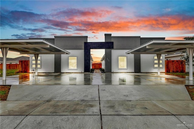 modern home with fence and stucco siding