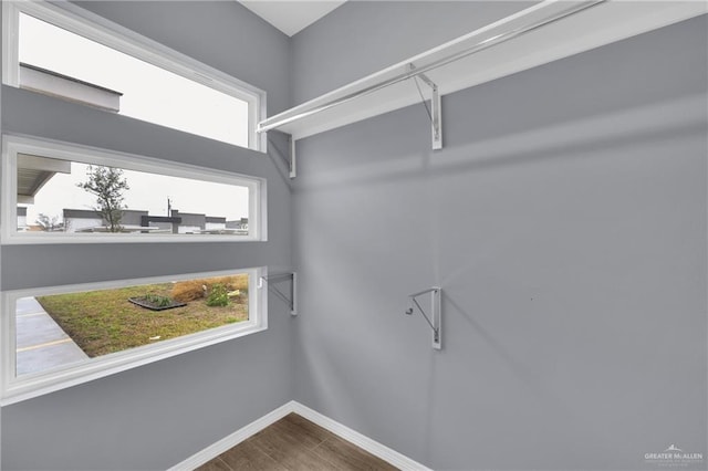 walk in closet with wood finished floors