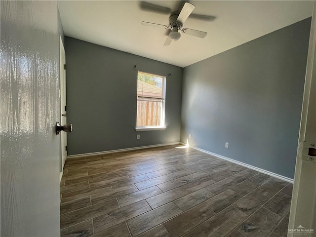 empty room with a ceiling fan, baseboards, and wood finish floors